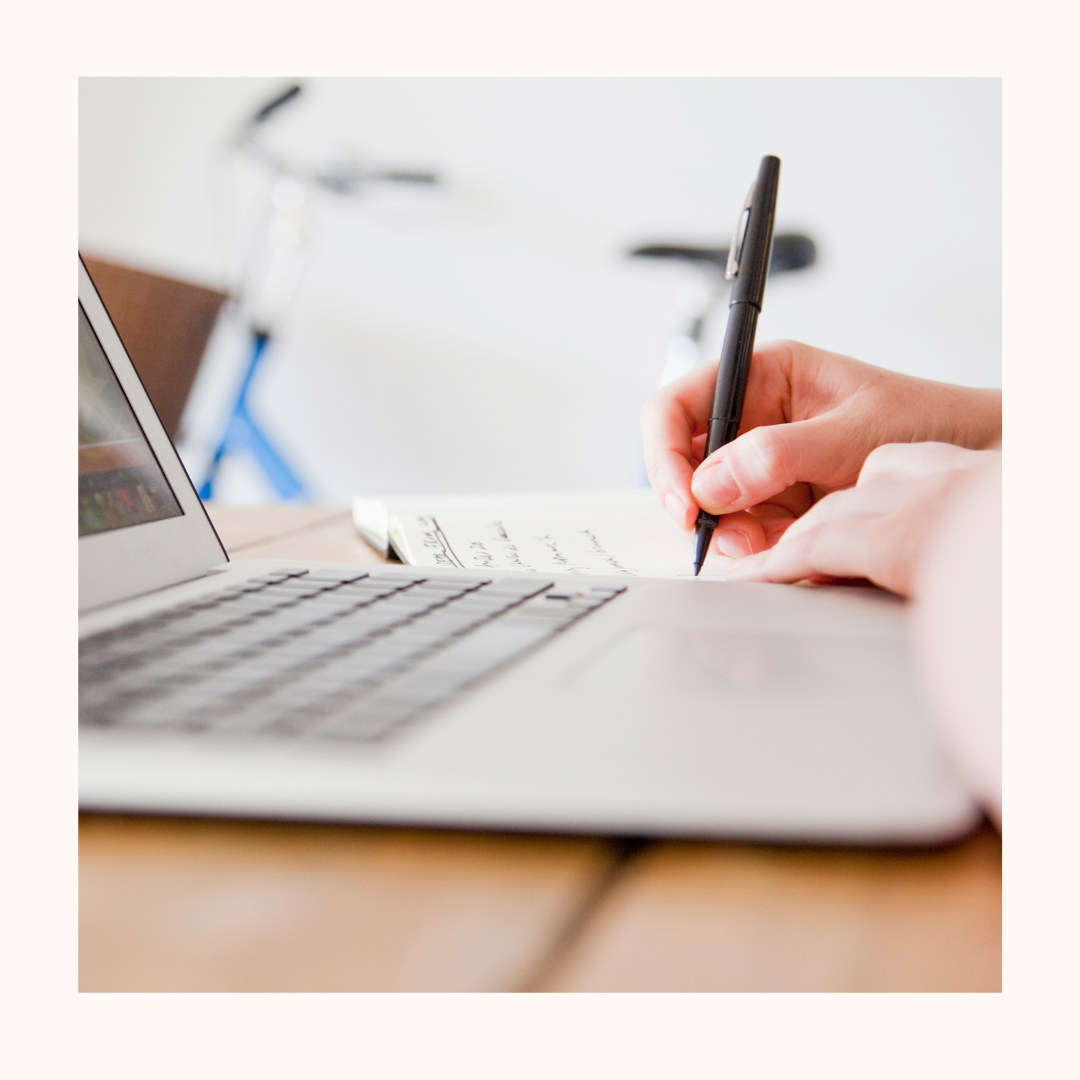 photo d'un clavier d'ordinateur et une main tenant un stylo