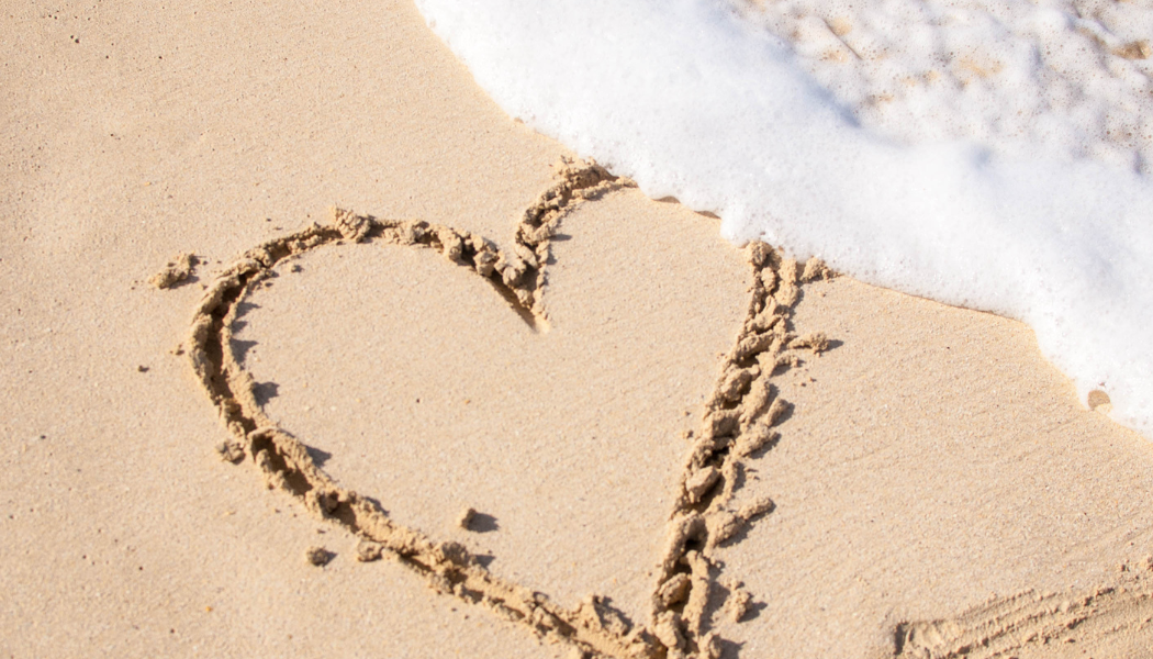 plage avec un cœur dessiné sur le sable